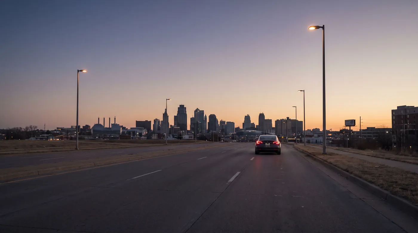 A wide empty road at dawn, the city skyline ahead.